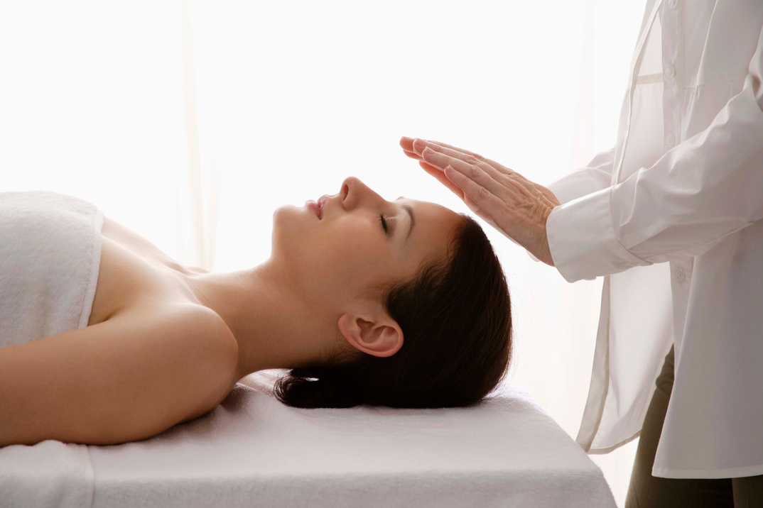 Woman having a reiki massage therapy treatment